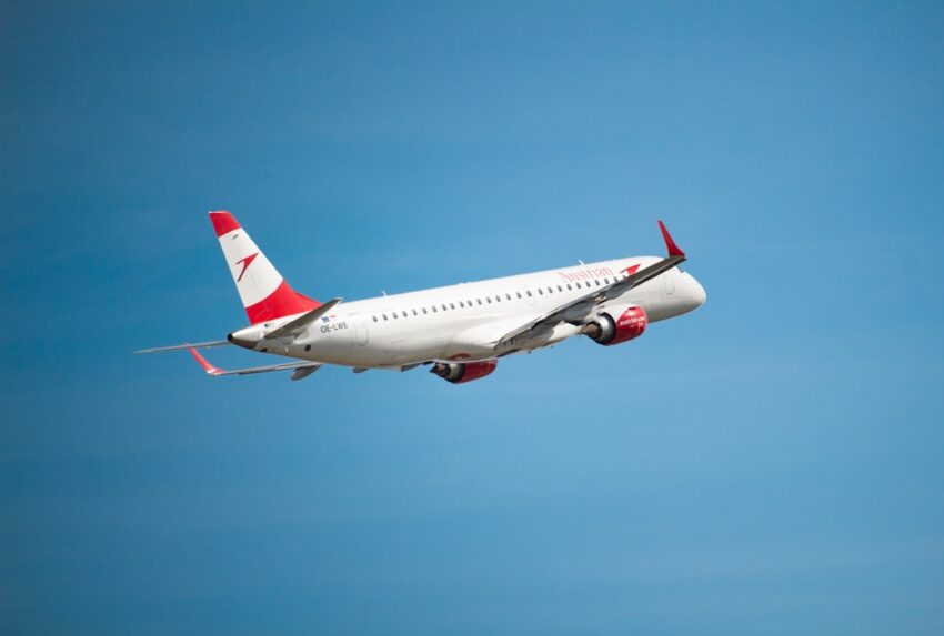 A plane takes flight against a blue sky.